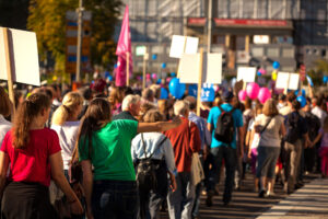 Group of people gathered at a protest, raising signs and demonstrating for human rights and justice